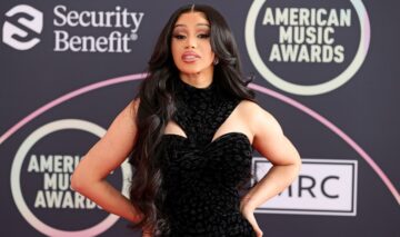 Cardi B îmbrăcată într-o rochie neagră fără mâneci cu decupaje mici deasupra sânilor