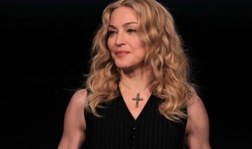 Madonna îmbrăcată într-o rochie neagră fără mâneci, asortată cu un lanț cu cruce